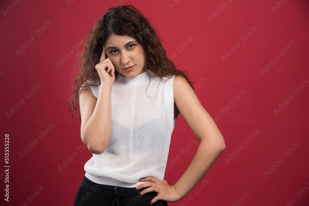 Portrait of young woman thinking on red background Portrait of young woman thinking on red background