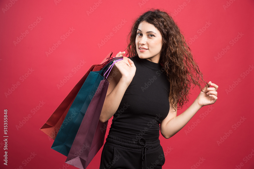 Happy woman with many of bags on red background Happy woman with many of bags on red background