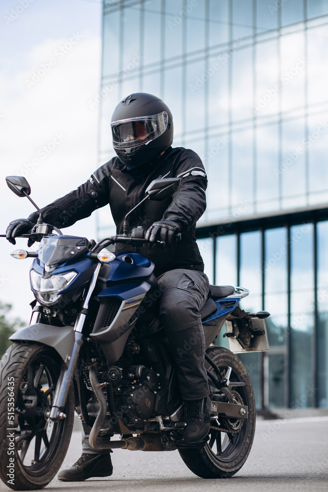 Handsome motorcyclist on his moto riding in the city Handsome motorcyclist on his moto riding in the city