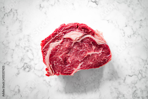 Cut of rib-eye steak on a marble counter top, close-up
