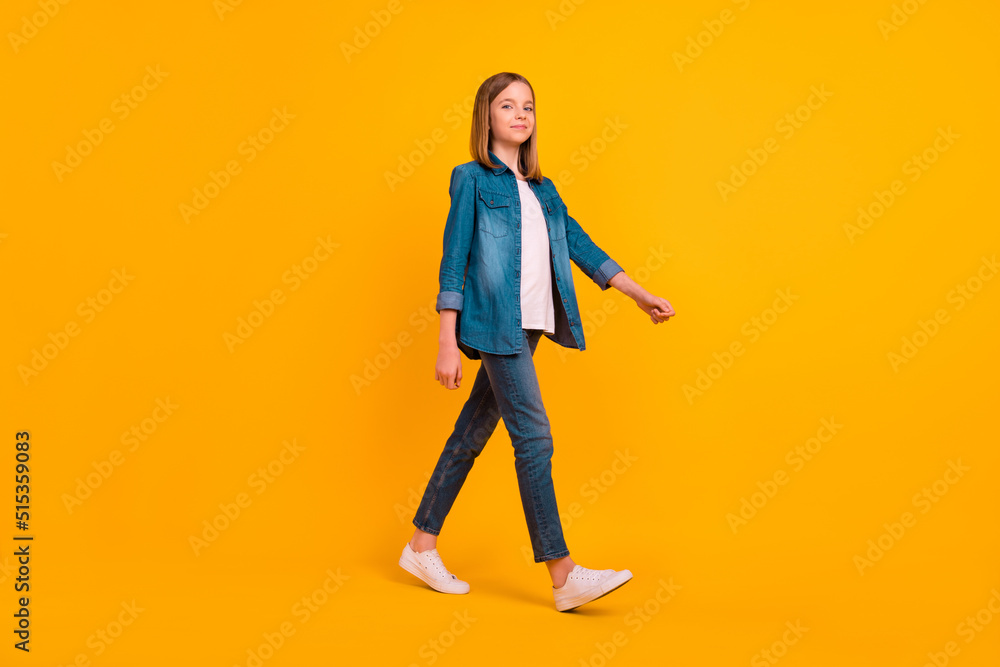 Full length profile photo of nice adorable girl walking have good mood isolated on yellow color background Full length profile photo of nice adorable girl walking have good mood isolated on yellow color background