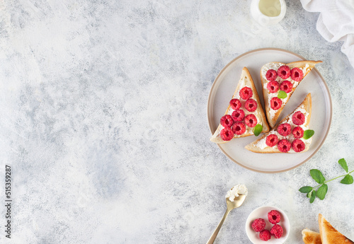 Toast with raspberries on a gray background, copy space