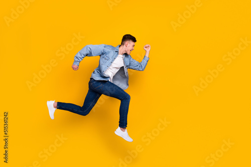 Full body profile side photo of young man runner jumper rush discount isolated over yellow color background