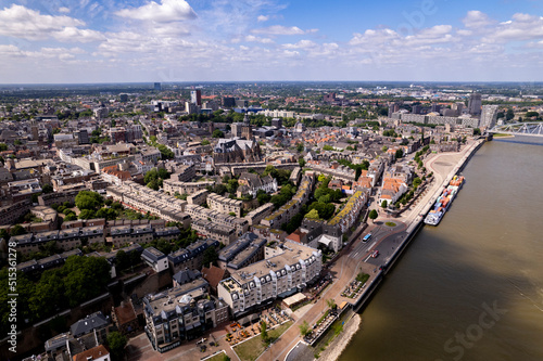 Aerial cityscape of Dutch Hanseatic town seen from above along the river Waal on a warm sunny day © Maarten Zeehandelaar