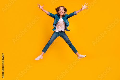Full body photo of overjoyed satisfied person jumping raise opened arms falling isolated on yellow color background