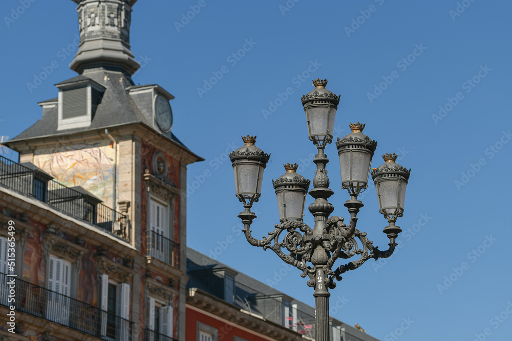 Beautiful view of the famous landmark Plaza Mayor with statue from Madrid, Spain, during a hot summer day with blue sky and the architecture vintage details in frame.