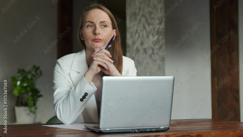 A thoughtful, pretty young business woman sitting at a desk with a pencil in her hand and dreaming about a new startup project. A thoughtful, pretty young business woman sitting at a desk with a pencil in her hand and dreaming about a new startup project.