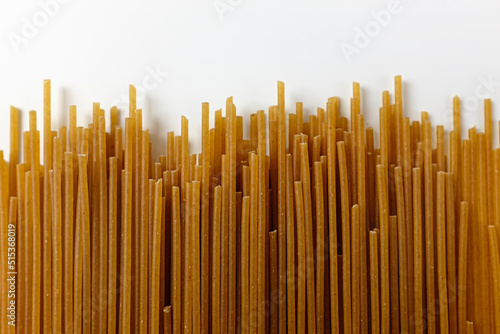 Whole wheat spaghetti on a white background