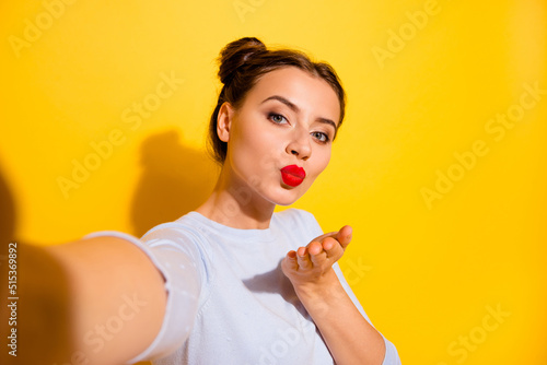 Photo of adorable shiny lady wear long sleeve recording self video sending you arm kiss isolated yellow color background photo