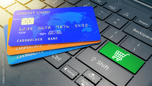 Credit cards on laptop with green shopping cart key. Internet online payment with credit card concept. 