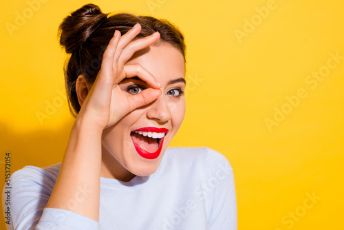 Fotografi Portrait of young adorable young excited female looking through okay symbol isol