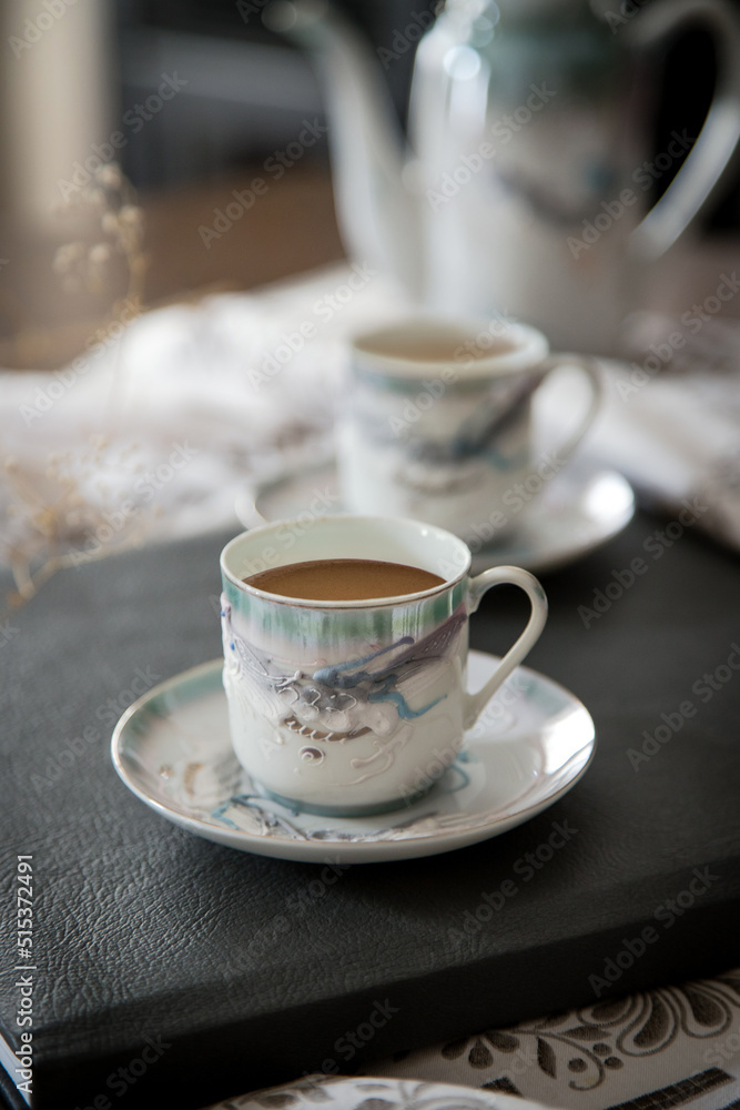 Breakfast or coffee break in a rustic, intimate and cozy atmosphere. Coffee served and ready to drink in cups crafted on an ornate table. Breakfast or coffee break in a rustic, intimate and cozy atmosphere. Coffee served and ready to drink in cups crafted on an ornate table.
