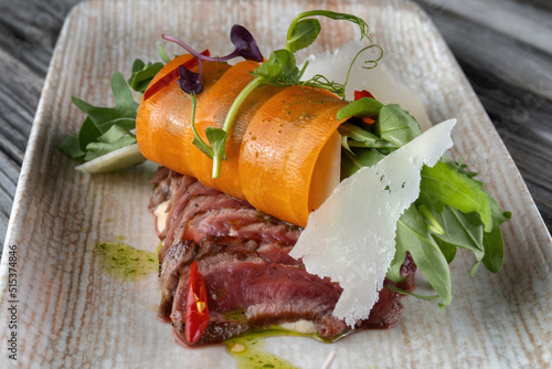 Roasted duck breast sliced, laid out on a plate. Haute cuisine, garnished with carrots.