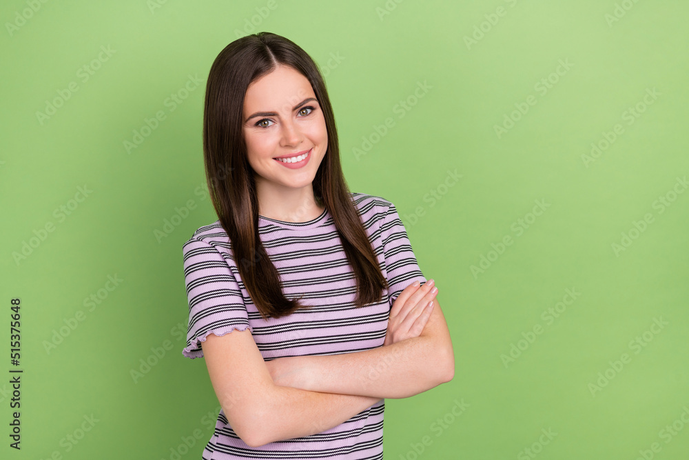Portrait of attractive glad cheerful brown-haired content girl folded arms isolated over bright green color background Portrait of attractive glad cheerful brown-haired content girl folded arms isolated over bright green color background