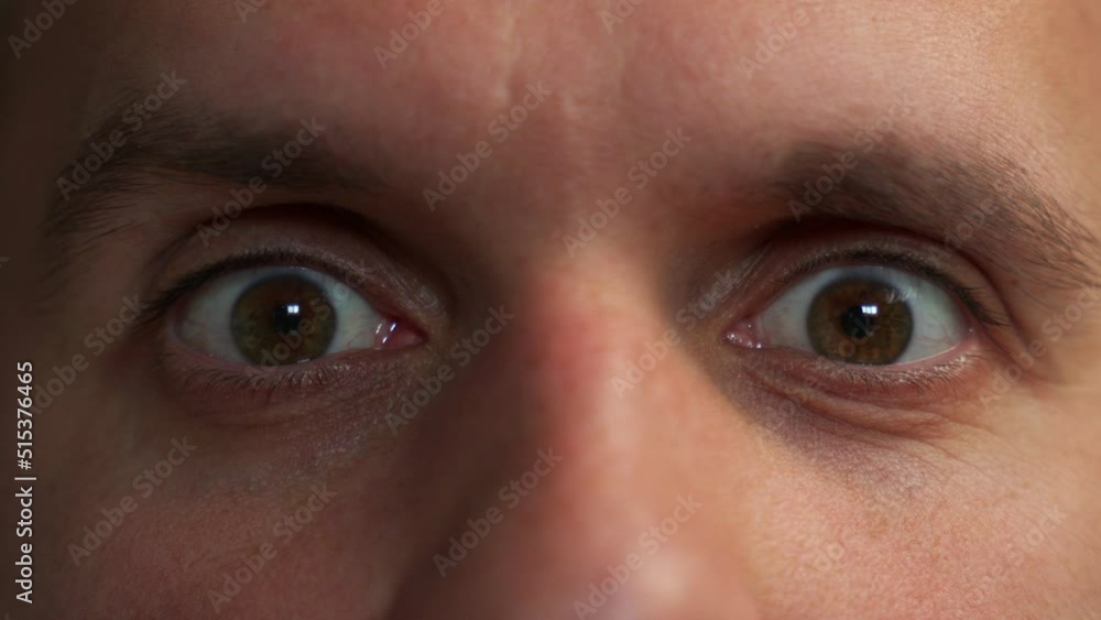 Close-up of a man's face. A man opens his beautiful brown eyes looking into the camera Close-up of a man's face. A man opens his beautiful brown eyes looking into the camera