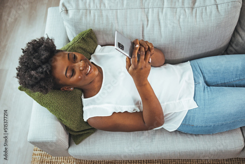 Cuadro en lienzo Woman using mobile phone while sitting on sofa