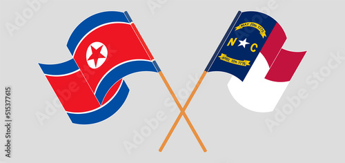 Crossed and waving flags of North Korea and The State of North Carolina