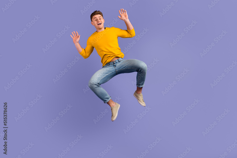 Full length photo of young guy have fun jump up wear casual clothes isolated over violet color background