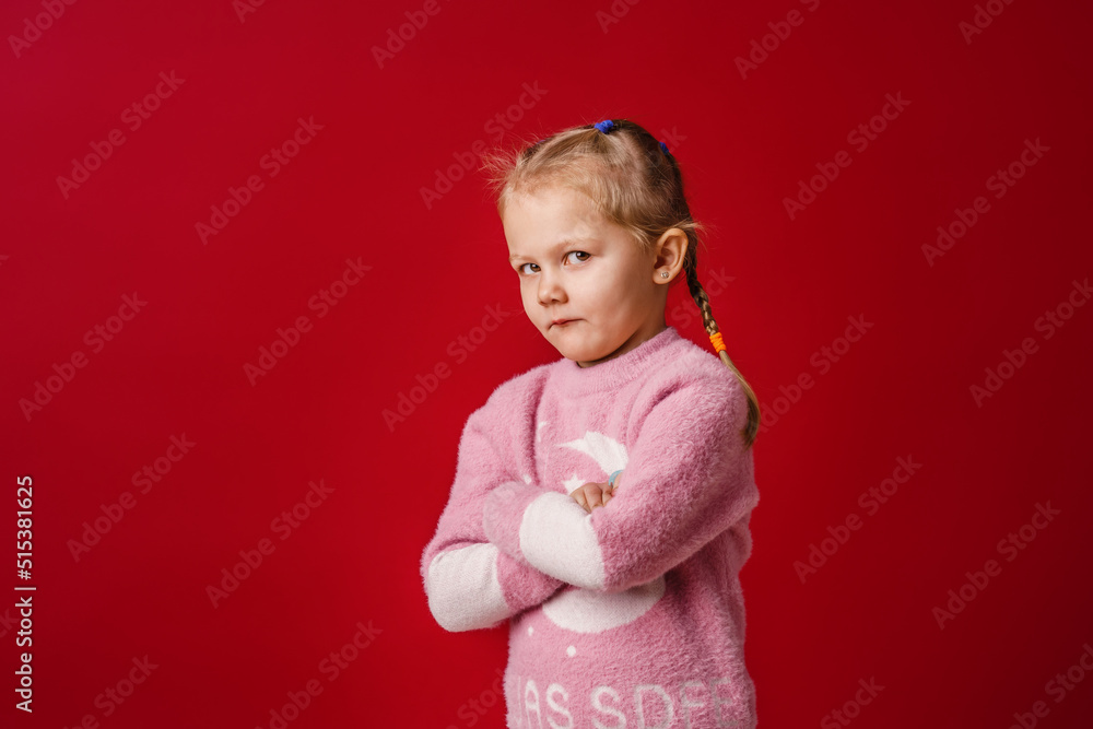 cute little Caucasian girl of 5 years old, insulted and offended on a red background. The baby is tired, capricious and turns away. Does not make contact. Close-up cute little Caucasian girl of 5 years old, insulted and offended on a red background. The baby is tired, capricious and turns away. Does not make contact. Close-up