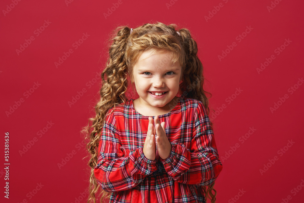 cunning little girl, 7 years old, plotting something bad, meanness, a child with an insidious expression looks at the camera standing on a red background in the studio. cunning little girl, 7 years old, plotting something bad, meanness, a child with an insidious expression looks at the camera standing on a red background in the studio.