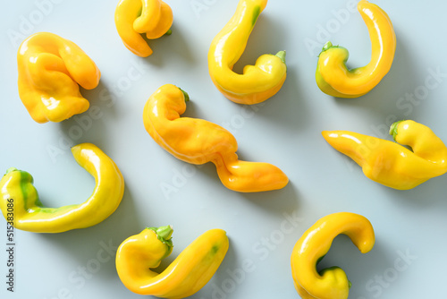 Abnormal ugly organic yellow pepper on blue background. View from above. Flat lay. Food pattern. photo