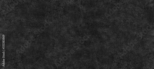 Fine textured shabby black surface wide abstract background. Dark gray spotty grainy texture. Gloomy grunge widescreen wallpaper