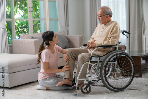 Young asian woman and old asian man with wheelchair at home