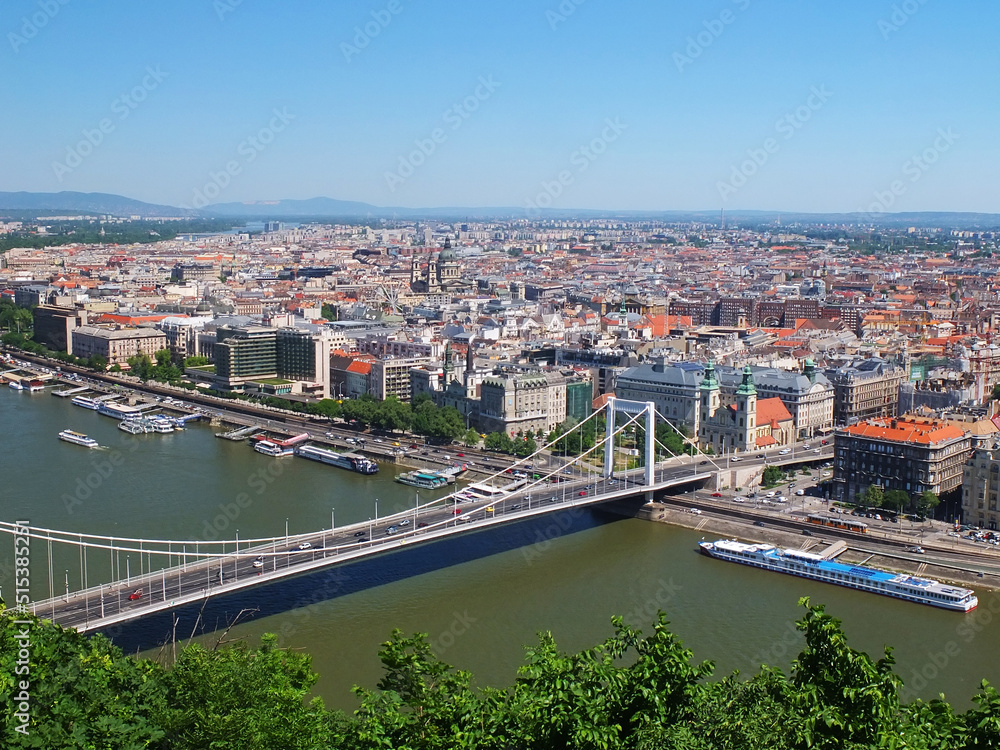 City of Budapest in Hungary. View of the city from above. Bridge over the Danube river. Ships and boats. Blue sky and skyline. European city