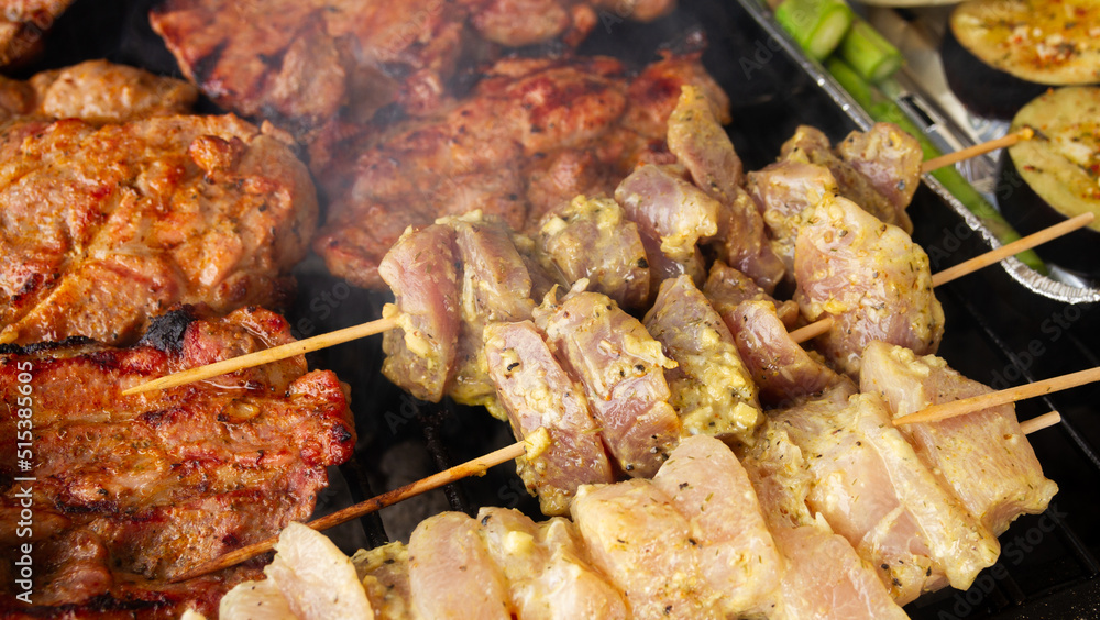 Roasted pork neck slices and chunks of chicken on skewer shashlik. Marinated meat on a barbecue grill. Roasted pork neck slices and chunks of chicken on skewer shashlik. Marinated meat on a barbecue grill.