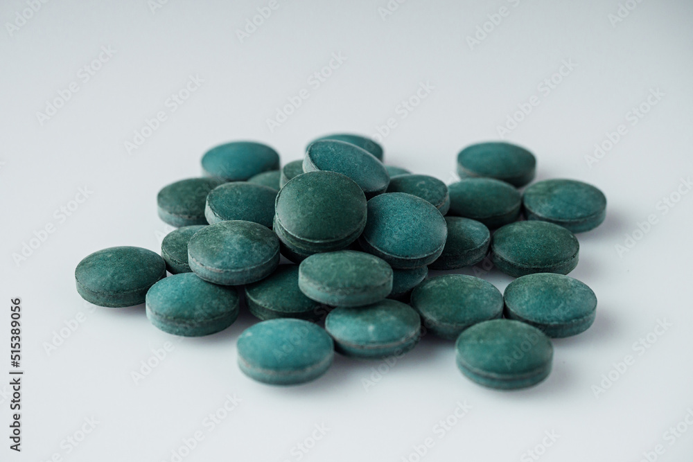 green spirulina dried seaweed on a white acrylic background green spirulina dried seaweed on a white acrylic background