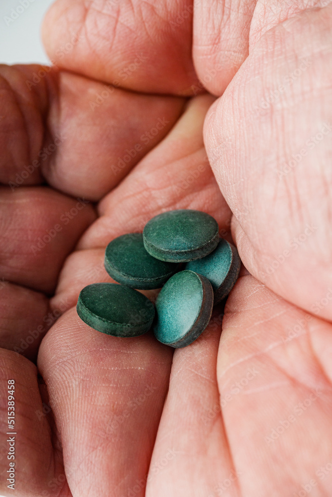 green spirulina dried seaweed in the hand of an old man green spirulina dried seaweed in the hand of an old man