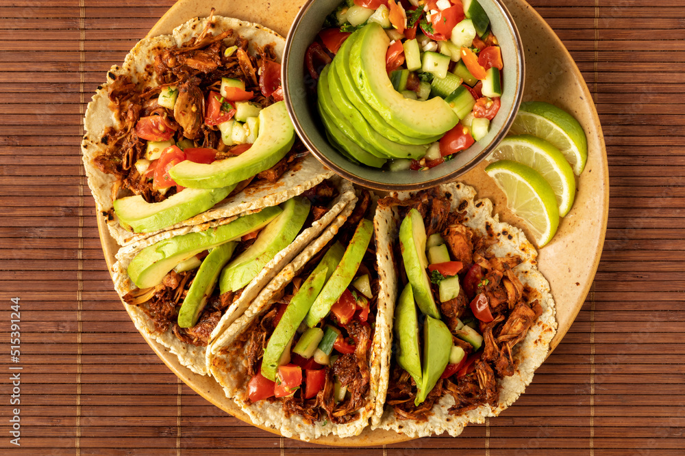 Shredded jackfruit tacos with avocado and pico de gallo salsa. Mexican vegan cuisine dish. Shredded jackfruit tacos with avocado and pico de gallo salsa. Mexican vegan cuisine dish.