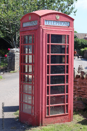 An old British telephone box at the entrance to the National Trust car park in the village of Bossington in Somerset, England