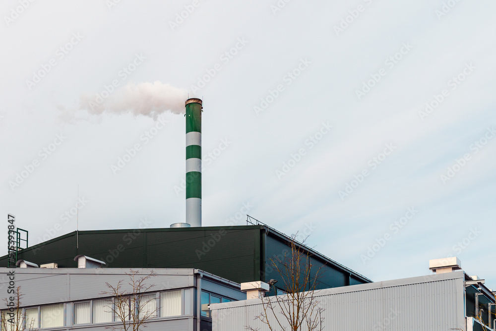 Chemical factory,smoke stack,CO2 greenhouse gas emissions coming from the smoking chimney pipe.Cloudy blue sky background.Copy space.