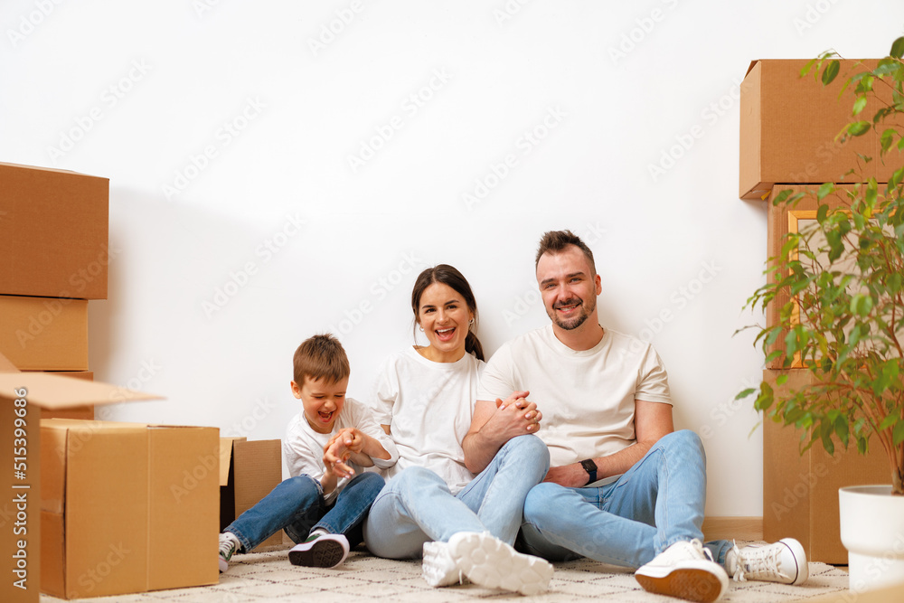 Young parents and son having fun during moving day to new house Young parents and son having fun during moving day to new house