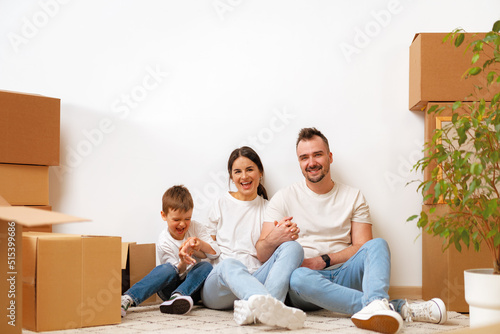 Young parents and son having fun during moving day to new house