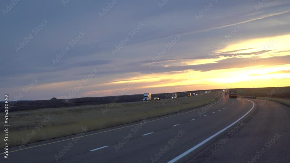 A cargo container semi-trailer carrying goods driving on an empty interstate highway through prairie fields in texas, america. Trailer carrying cargo on a sunny morning A cargo container semi-trailer carrying goods driving on an empty interstate highway through prairie fields in texas, america. Trailer carrying cargo on a sunny morning