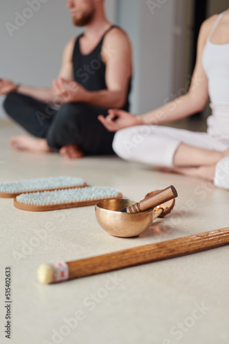 Selective focus. Practice of standing on nails. Group of people meditation after practice of standing on sadhu board in yoga studio with TIBETAN BOWLS. Concept on healthy lifestyle.