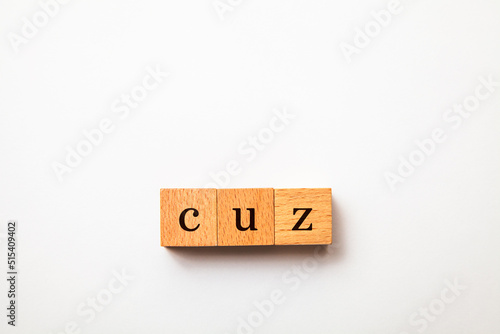 cuzの文字。なぜなら。理由。3つの木製ブロックに書かれている。黒い文字。白い背景。