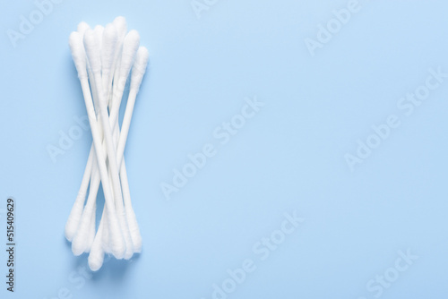 White new clean cotton swabs buds on blue background top view flay lay with side copy-space