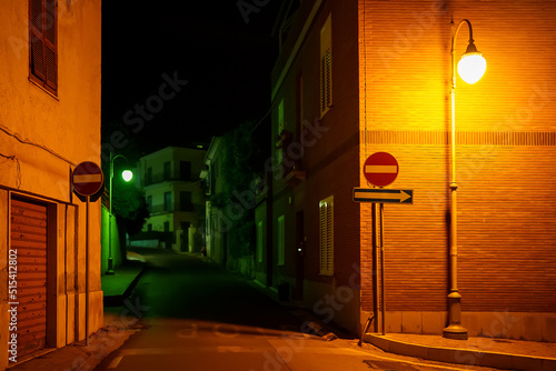 Night street with yellow and green lighting. photo