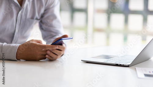 Business man using a mobile phone on the desk in the office.