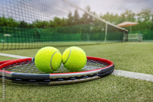 Canvas Print tennis racket and balls on synthetic grass outdoor court