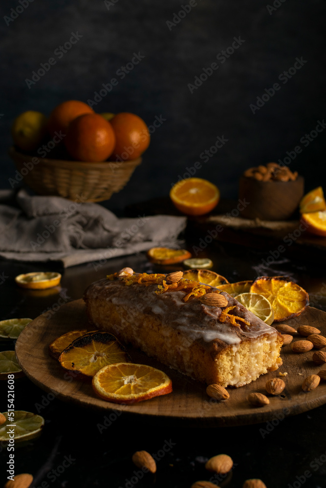 orange cake pudding with almonds and whole and sliced natural oranges and orange juice on a dark table orange cake pudding with almonds and whole and sliced natural oranges and orange juice on a dark table