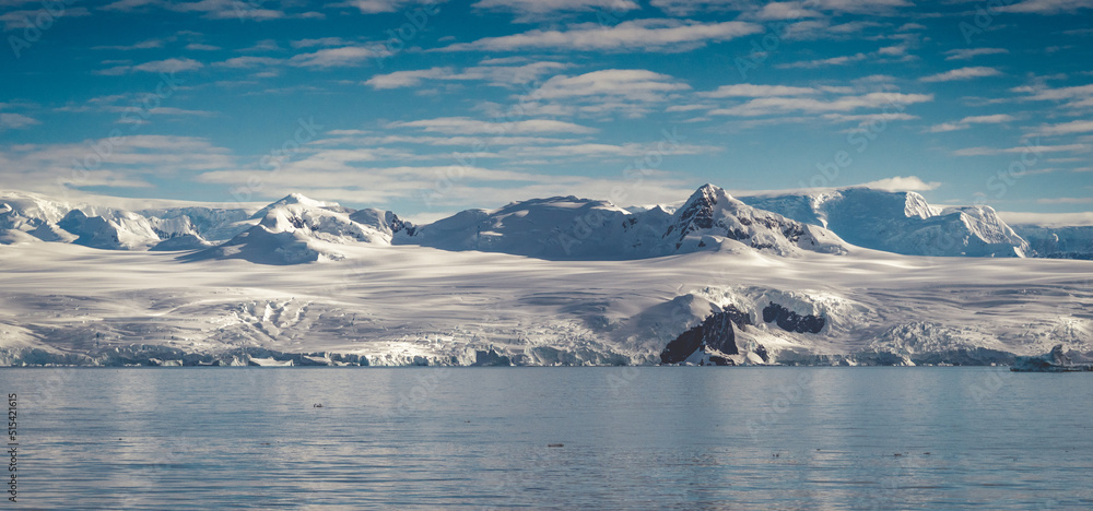 Antarctica mountains and sea. Clouds and blue sky