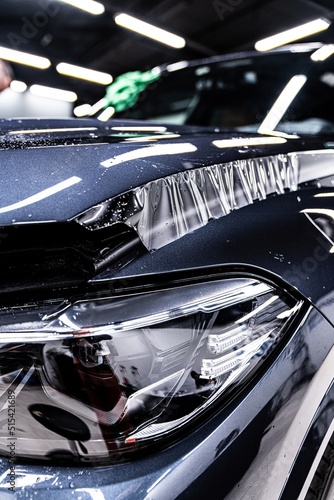 Hood of a modern car during the application of a tranparent protective film in a car detailing studio © Daniel Jędzura