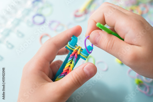 Wallpaper Mural A girl makes a rainbow bracelet from rubber bands crochet. Closeup of making decorative bracelet with elastic bands. Loom bracelets Torontodigital.ca