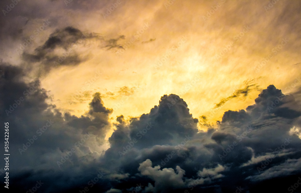 Naklejka premium Yellow sky with dark clouds and sunbeams
