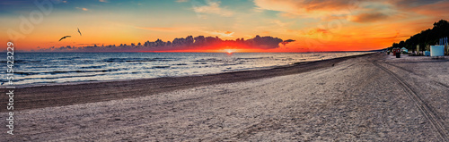 Colorful sunrise on sandy beach of the Baltic Sea, panoramic image. Jurmala, ...