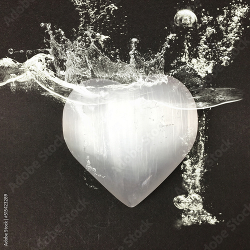 Heart shaped selenite crystal with energy aura and water splashes. Raise your vibration higher with clean pure selenite for well being. photo